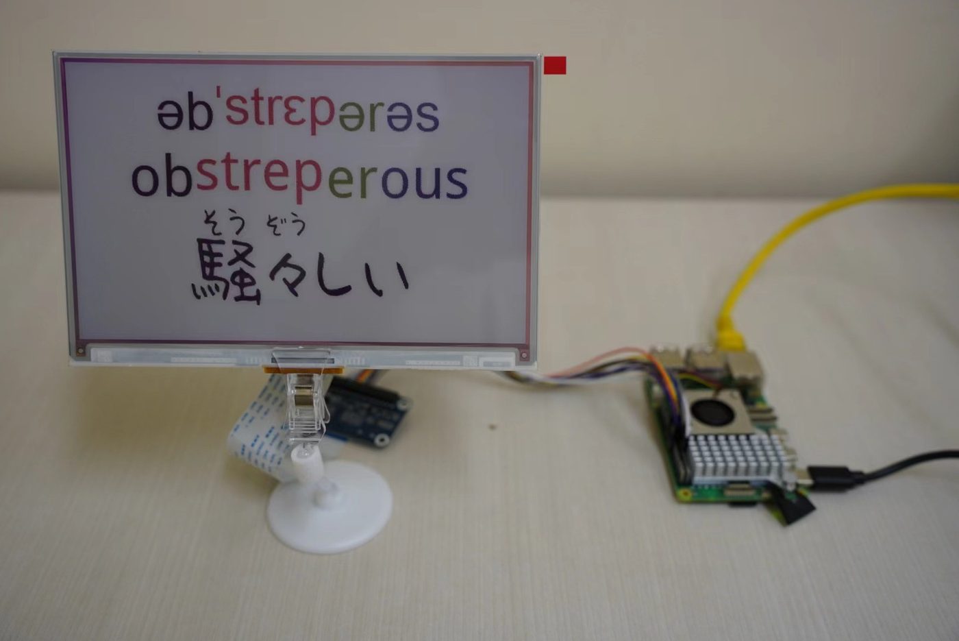 E-ink words card showing 'obstreperous' with IPA and Japanese, driven by a Raspberry Pi